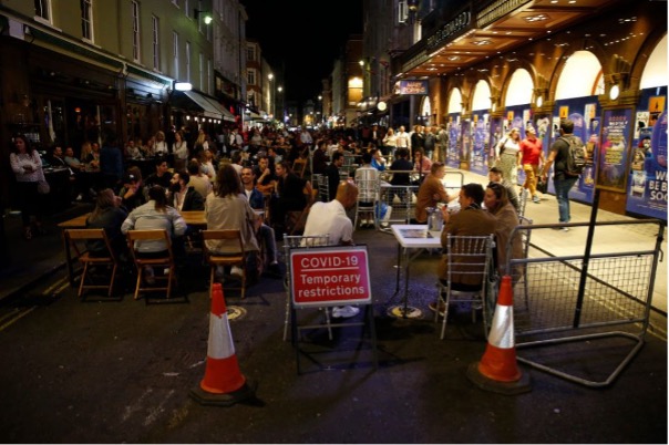 People filling the streets of Soho to enjoy an evening of outdoor dining
